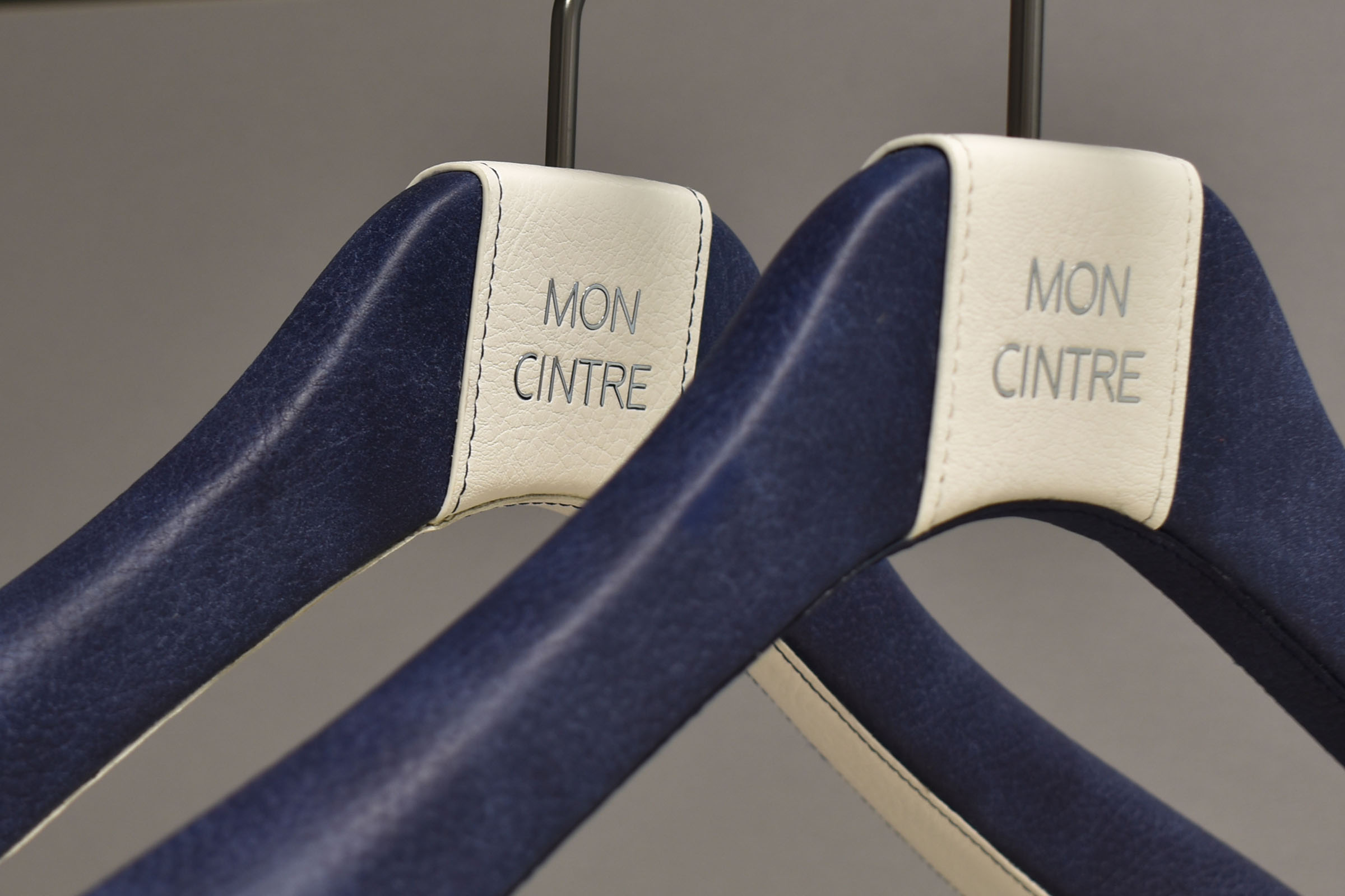 Cintres gainés de cuir avec logo en lettres métalliques